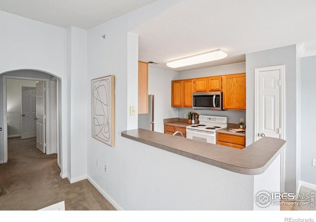 5620 Fossil Creek Pkwy Unit 6303, Fort Collins, CO 80525 - kitchen with white range with electric cooktop, stainless steel microwave, carpet floors, arched walkways, and a peninsula