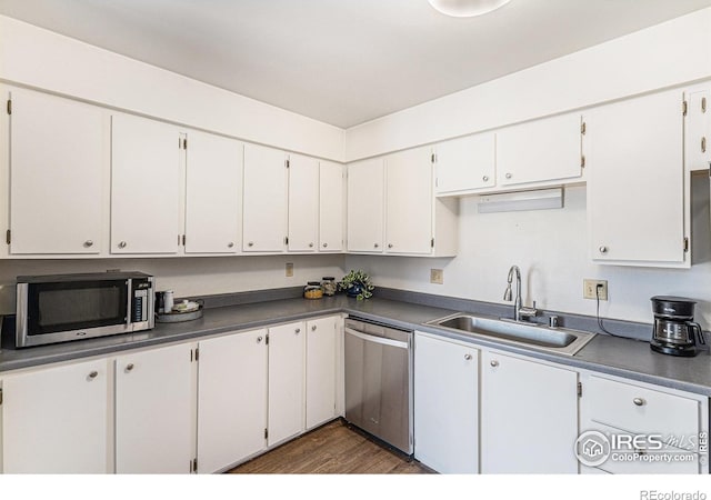7250 Eastmoor Dr, Denver, CO 80237 - kitchen with stainless steel appliances, dark wood finished floors, dark countertops, and white cabinets