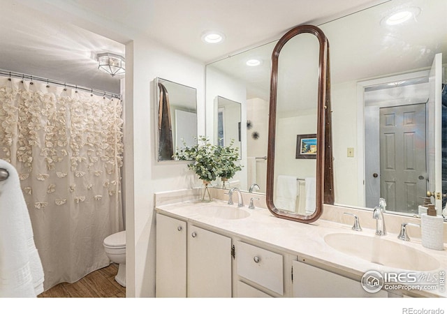 7250 Eastmoor Dr, Denver, CO 80237 - bathroom with double vanity, wood finished floors, and recessed lighting