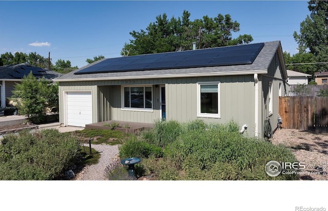 7850 Raleigh Pl, Westminster, CO 80030 - ranch-style home with a shingled roof, solar panels, and a garage