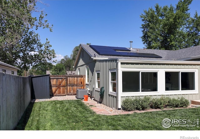 7850 Raleigh Pl, Westminster, CO 80030 - view of home's exterior featuring a shingled roof, solar panels, board and batten siding, and a gate