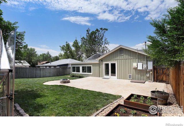 7850 Raleigh Pl, Westminster, CO 80030 - rear view of house with board and batten siding, an outdoor fire pit, a patio area, a garden, and a fenced backyard