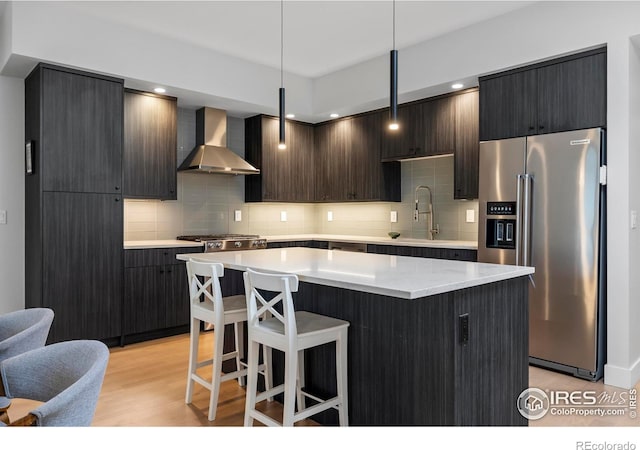 2718 Pine St Unit 301, Boulder, CO 80302 - kitchen with high end fridge, wall chimney range hood, decorative backsplash, a center island, and a breakfast bar area