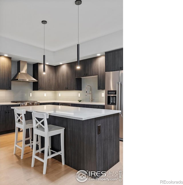 2718 Pine St Unit 301, Boulder, CO 80302 - kitchen featuring wall chimney range hood, high end refrigerator, a center island, and tasteful backsplash