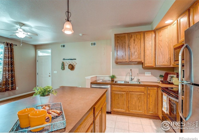 2131 Grays Peak Dr Unit 102, Loveland, CO 80538 - kitchen featuring appliances with stainless steel finishes, decorative light fixtures, a ceiling fan, light countertops, and light tile patterned floors