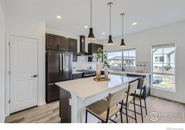 945 Abbott Ln Unit 2, Fort Collins, CO 80524 - kitchen with wall chimney exhaust hood, appliances with stainless steel finishes, tasteful backsplash, light wood-style flooring, and recessed lighting