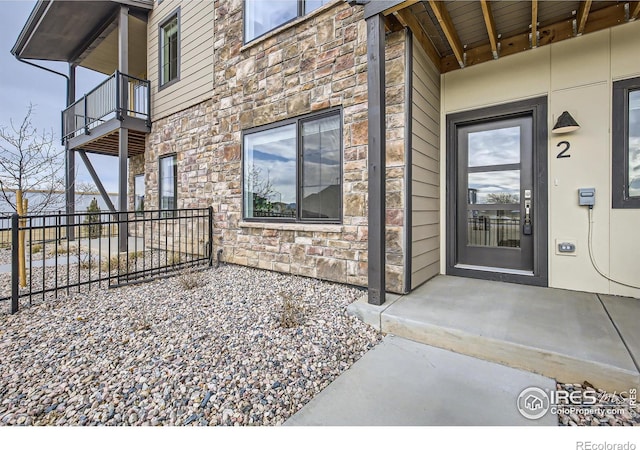 945 Abbott Ln Unit 2, Fort Collins, CO 80524 - view of exterior entry with stone siding and a balcony