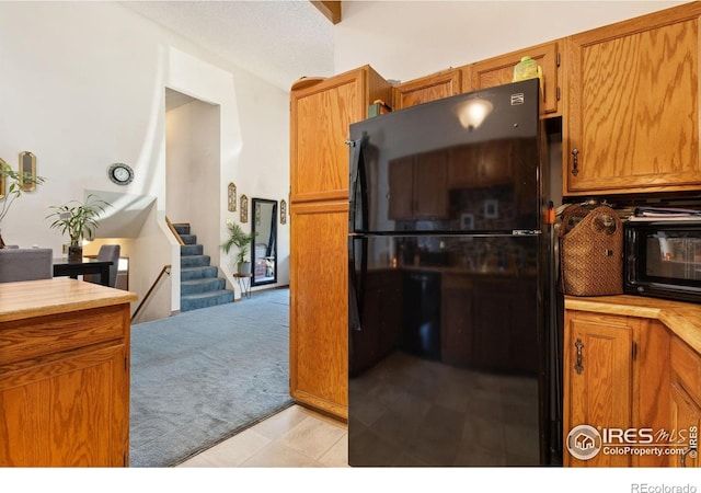 1200-1202 Parker Dr, Longmont, CO 80501 - kitchen with freestanding refrigerator, light carpet, and brown cabinets