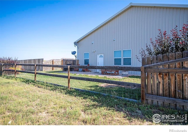18441 Bandana Ln, Wellington, CO 80549 - rear view of house with a fenced backyard, board and batten siding, and a patio