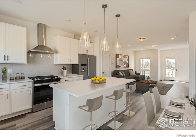 919 Schlagel St Unit 3, Fort Collins, CO 80524 - kitchen featuring wall chimney range hood, stainless steel appliances, a center island, light wood-type flooring, and recessed lighting