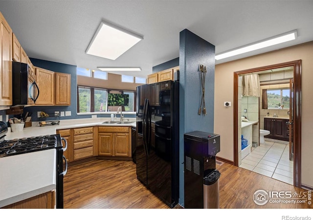 228 Mount Everest Dr, Livermore, CO 80536 - kitchen with black appliances, wood finished floors, light countertops, and plenty of natural light