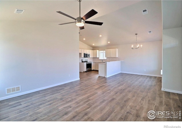 4327 Primrose Ln, Evans, CO 80620 - unfurnished living room featuring a chandelier, vaulted ceiling, a ceiling fan, recessed lighting, and wood finished floors