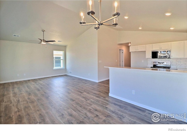 4327 Primrose Ln, Evans, CO 80620 - kitchen with appliances with stainless steel finishes, lofted ceiling, a chandelier, white cabinetry, and decorative backsplash