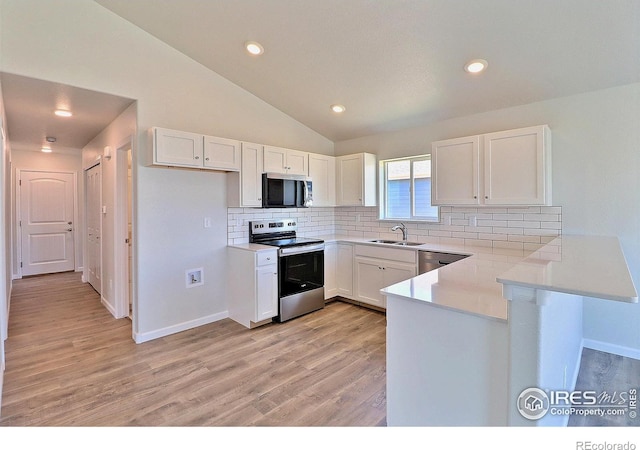4327 Primrose Ln, Evans, CO 80620 - kitchen featuring stainless steel appliances, a peninsula, white cabinetry, tasteful backsplash, and light wood-style flooring