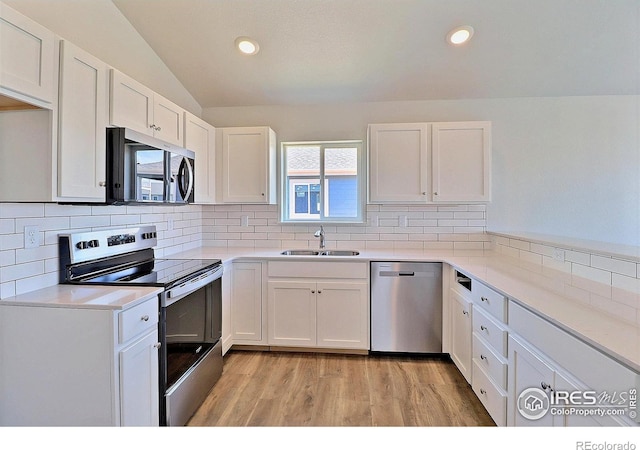 4327 Primrose Ln, Evans, CO 80620 - kitchen featuring stainless steel appliances, white cabinets, tasteful backsplash, lofted ceiling, and recessed lighting