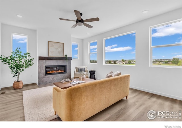 900 Eldorado Ln, Louisville, CO 80027 - living room with a tiled fireplace, healthy amount of natural light, light wood finished floors, ceiling fan, and recessed lighting