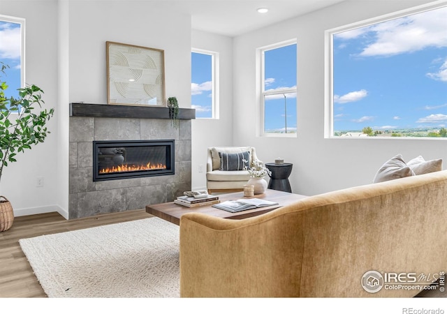 900 Eldorado Ln, Louisville, CO 80027 - living room featuring wood finished floors, a tiled fireplace, plenty of natural light, and recessed lighting