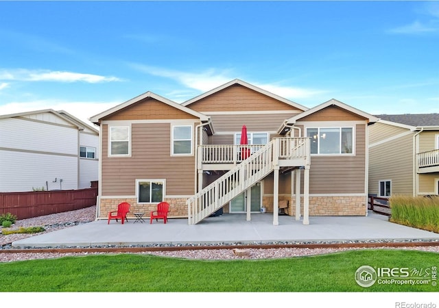 1774 Thrive Dr, Windsor, CO 80550 - rear view of property featuring stone siding, a patio, stairway, and a wooden deck