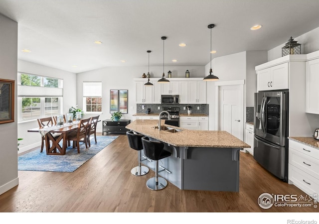 401 Cascade Ct, Johnstown, CO 80534 - kitchen featuring stainless steel appliances, dark wood-type flooring, backsplash, a kitchen island with sink, and white cabinetry