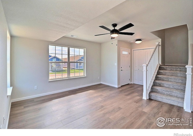 4319 Primrose Ln, Evans, CO 80620 - entrance foyer with wood finished floors, stairs, ceiling fan, and a textured ceiling