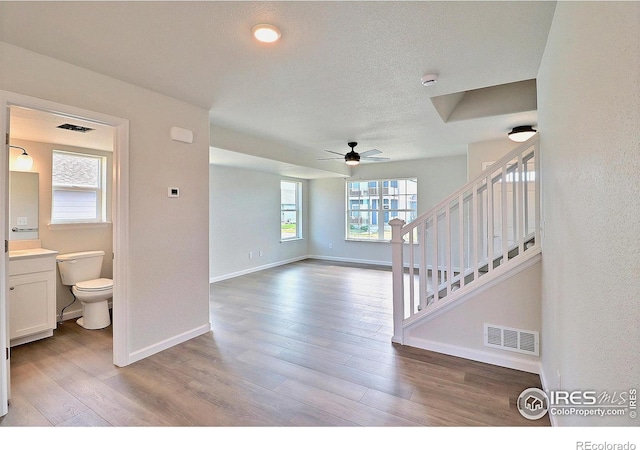 4319 Primrose Ln, Evans, CO 80620 - unfurnished living room featuring a ceiling fan, light wood-type flooring, and stairway