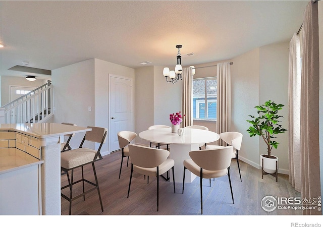4319 Primrose Ln, Evans, CO 80620 - dining room with light wood-style floors, a chandelier, and stairs