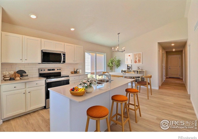 4315 Primrose Ln, Evans, CO 80620 - kitchen featuring stainless steel appliances, backsplash, white cabinetry, light wood-style floors, and light countertops