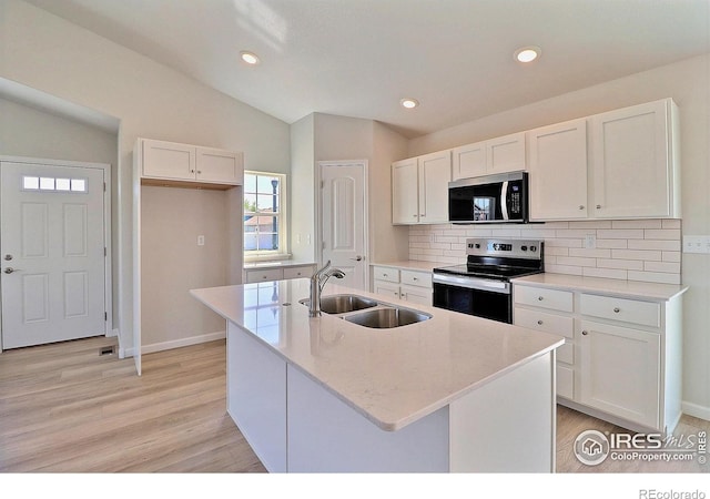 4315 Primrose Ln, Evans, CO 80620 - kitchen with appliances with stainless steel finishes, white cabinetry, tasteful backsplash, light wood-style flooring, and vaulted ceiling
