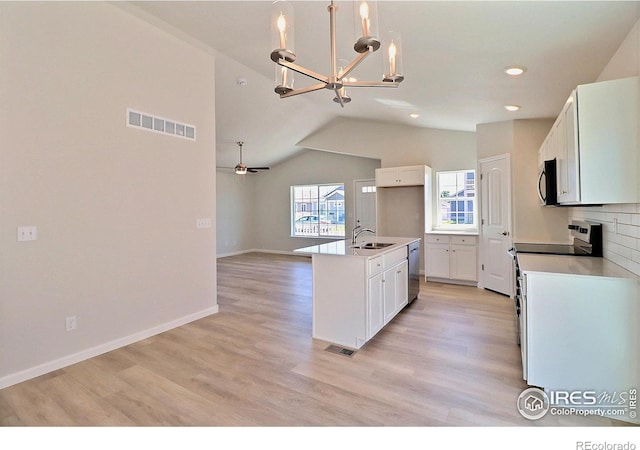4315 Primrose Ln, Evans, CO 80620 - kitchen with stainless steel appliances, a chandelier, vaulted ceiling, white cabinetry, and recessed lighting