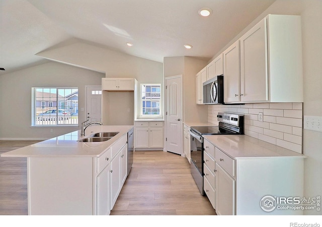 4315 Primrose Ln, Evans, CO 80620 - kitchen with appliances with stainless steel finishes, light wood finished floors, lofted ceiling, white cabinetry, and tasteful backsplash