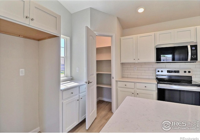 4315 Primrose Ln, Evans, CO 80620 - kitchen featuring stainless steel appliances, backsplash, light wood finished floors, white cabinetry, and recessed lighting