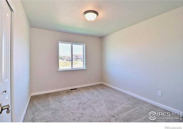 4315 Primrose Ln, Evans, CO 80620 - carpeted spare room with baseboards and a textured ceiling