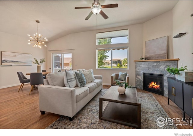2968 Hydra Dr, Loveland, CO 80537 - living room with wood finished floors, a glass covered fireplace, lofted ceiling, a chandelier, and ceiling fan