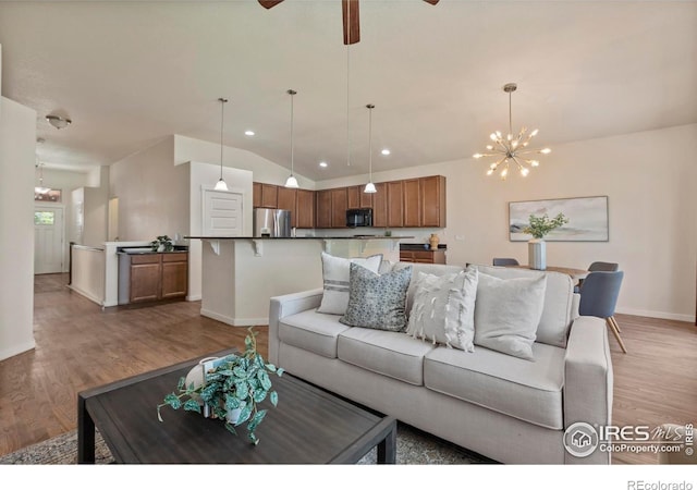 2968 Hydra Dr, Loveland, CO 80537 - living room with vaulted ceiling, light wood-style floors, a chandelier, recessed lighting, and ceiling fan