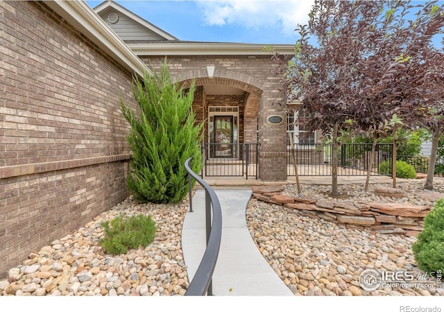 4283 Golf Vista Dr, Loveland, CO 80537 - doorway to property featuring brick siding and a gate