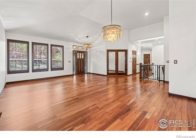 4283 Golf Vista Dr, Loveland, CO 80537 - unfurnished living room with wood finished floors, a chandelier, and lofted ceiling