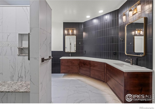 4283 Golf Vista Dr, Loveland, CO 80537 - bathroom with tile walls, marble look tile flooring, double vanity, water heater, and recessed lighting