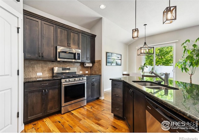 1625 Glacier Ave, Berthoud, CO 80513 - kitchen featuring stainless steel appliances, light wood-type flooring, decorative backsplash, lofted ceiling, and dark brown cabinets