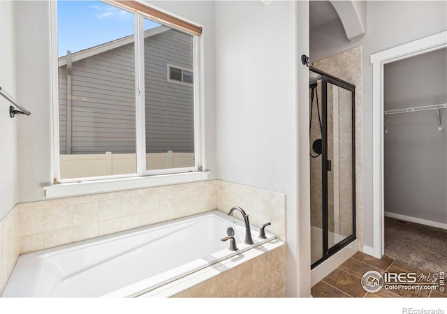 1625 Glacier Ave, Berthoud, CO 80513 - full bath featuring a shower stall, a garden tub, a walk in closet, and tile patterned flooring