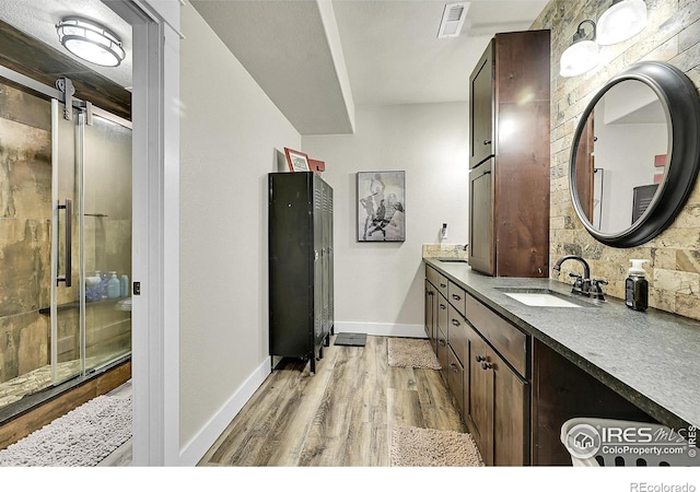 1115 Kestrel Rd, Eaton, CO 80615 - full bath featuring wood finished floors, vanity, and a shower with door