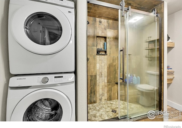 1115 Kestrel Rd, Eaton, CO 80615 - laundry area featuring estacked washer and dryer and wood finished floors