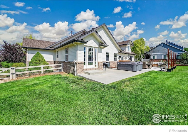 1115 Kestrel Rd, Eaton, CO 80615 - back of house with a hot tub, a patio, and brick siding