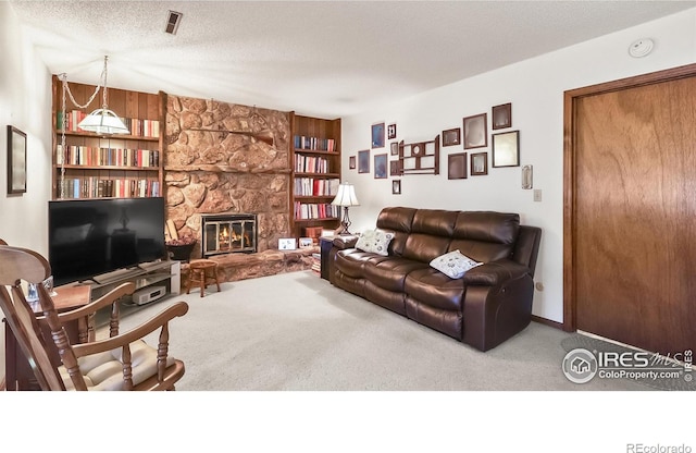 2937 Alamo Ave, Fort Collins, CO 80525 - living room with carpet, a stone fireplace, a textured ceiling, and built in features