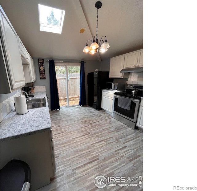 1031 N Lincoln Ave, Loveland, CO 80537 - kitchen with stainless steel appliances, under cabinet range hood, a skylight, tasteful backsplash, and a chandelier