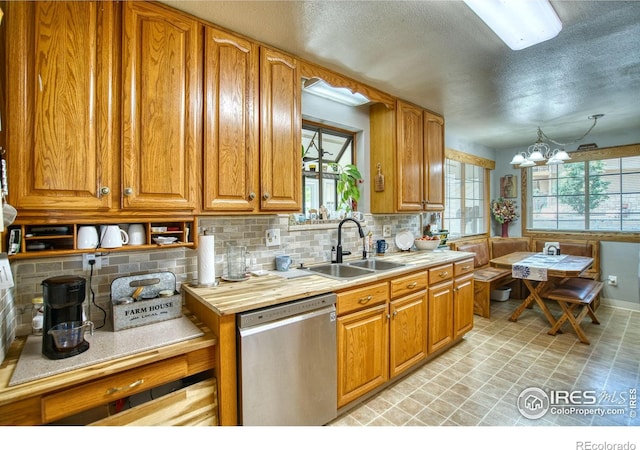 1400 Darton Dr, Johnstown, CO 80534 - kitchen featuring stainless steel dishwasher, plenty of natural light, light countertops, a textured ceiling, and a chandelier