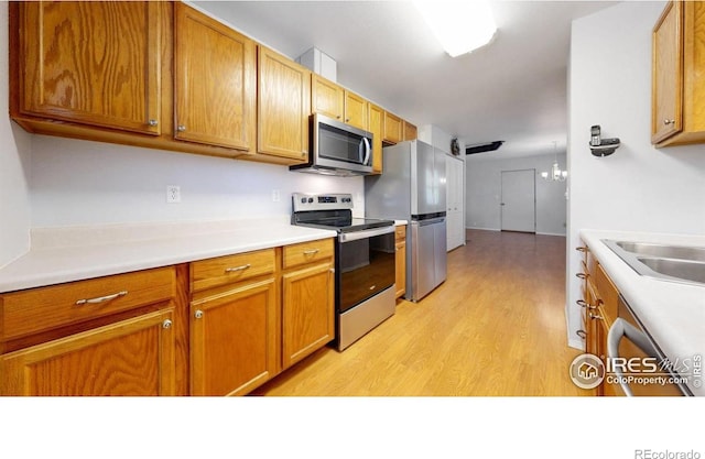 5001 W County Road 38 E, Fort Collins, CO 80526 - kitchen with appliances with stainless steel finishes, light wood-type flooring, light countertops, and brown cabinetry