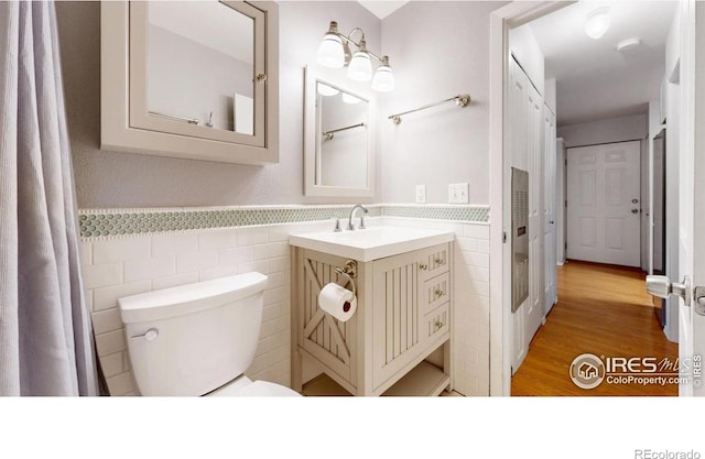 5001 W County Road 38 E, Fort Collins, CO 80526 - bathroom with tile walls, vanity, a wainscoted wall, and wood finished floors