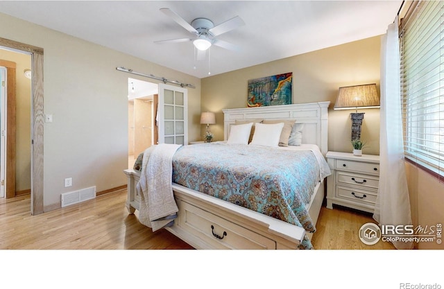 2319 Cotswold Ct, Fort Collins, CO 80526 - bedroom with light wood-style flooring, a barn door, and a ceiling fan