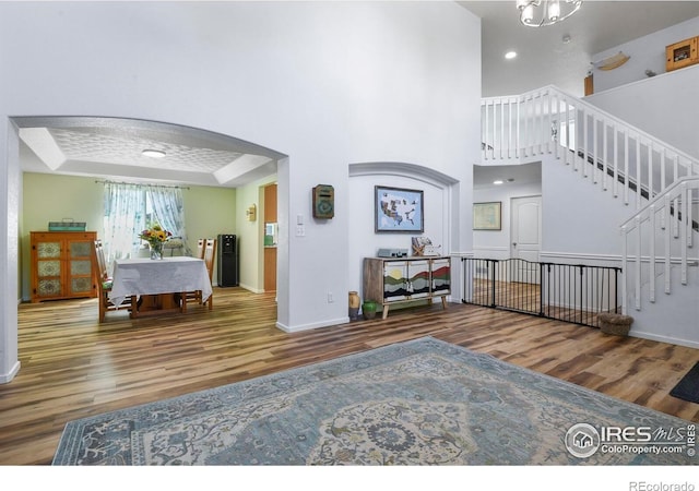 1169 Cooke Ct, Erie, CO 80516 - living room with wood finished floors, arched walkways, stairs, recessed lighting, and a tray ceiling