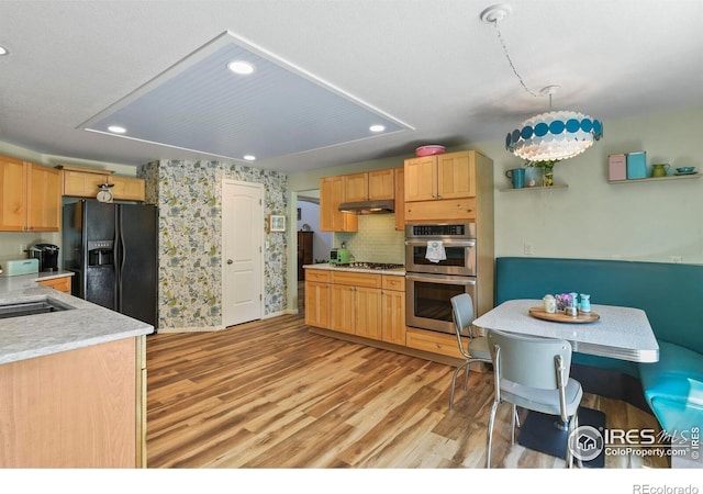 1169 Cooke Ct, Erie, CO 80516 - kitchen featuring stainless steel appliances, under cabinet range hood, recessed lighting, light countertops, and light wood-type flooring